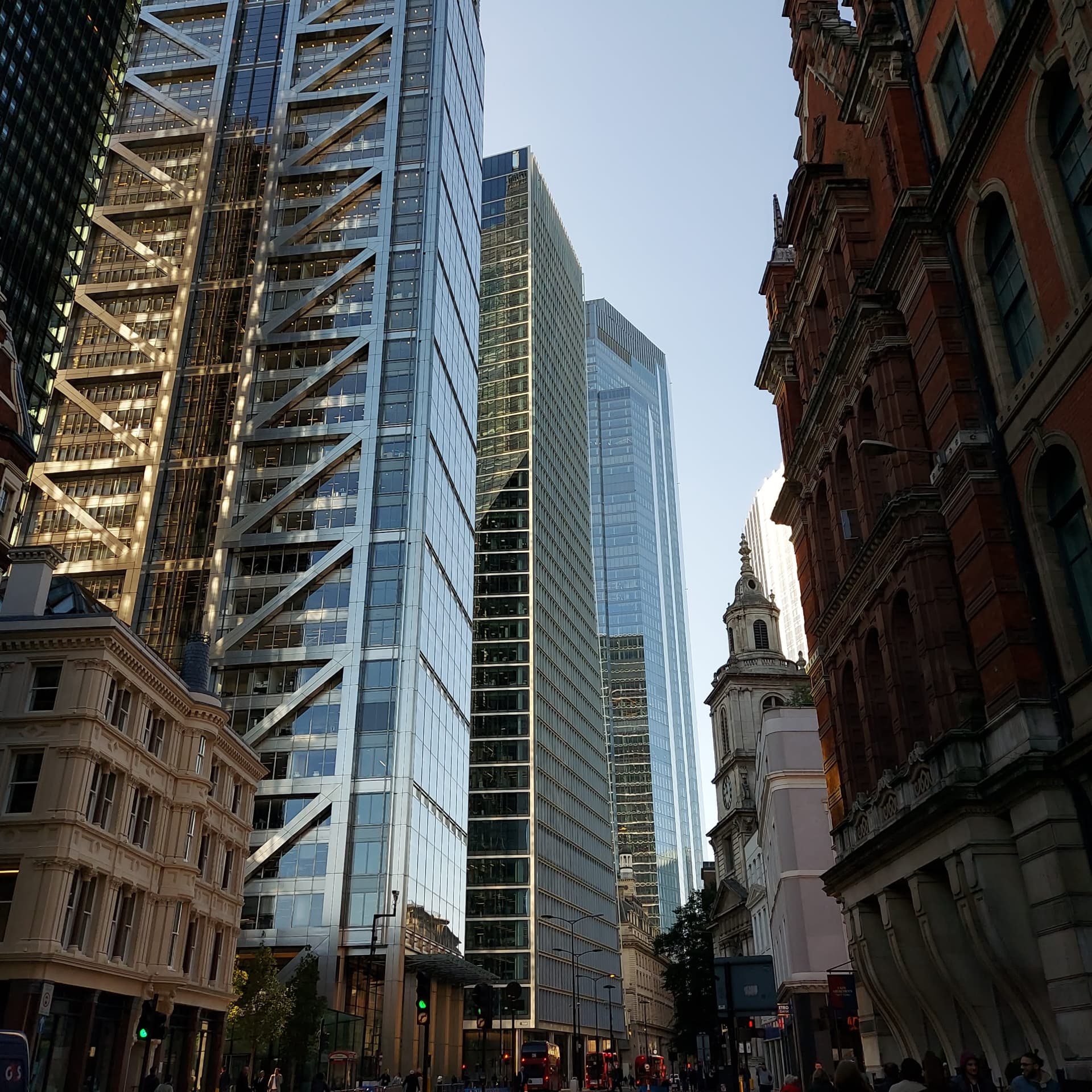 Modern glass and steel towers rising alongside historic brick architecture in the City of London.