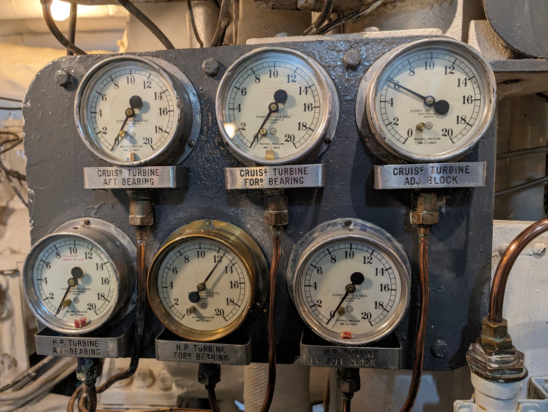 Industrial steam turbine pressure dials and bearing gauges on a mechanical control panel.