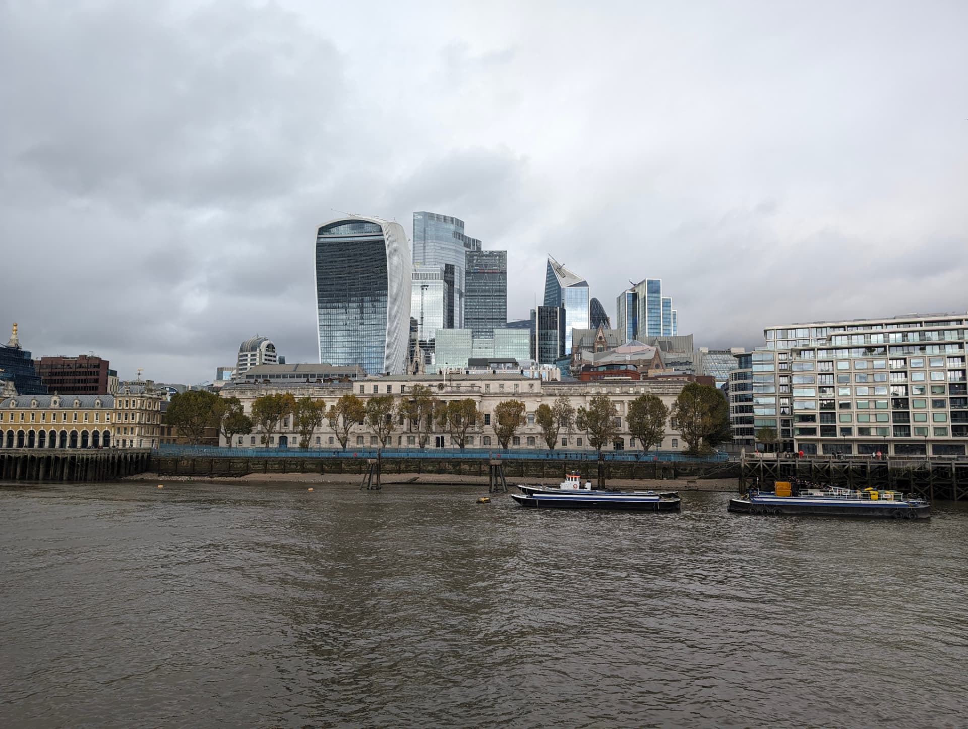 The River Thames and the City of London skyline, showing institutional and corporate towers across the water.